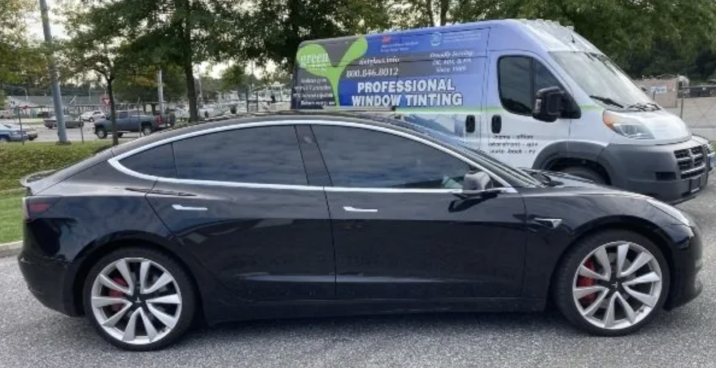 The need for car window tinting safety applies to all vehicles, including this black sedan.