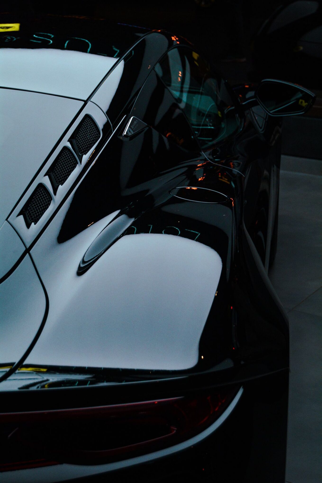 Glossy black sports car with deep reflections, the kind of finish paint protection film is designed to preserve